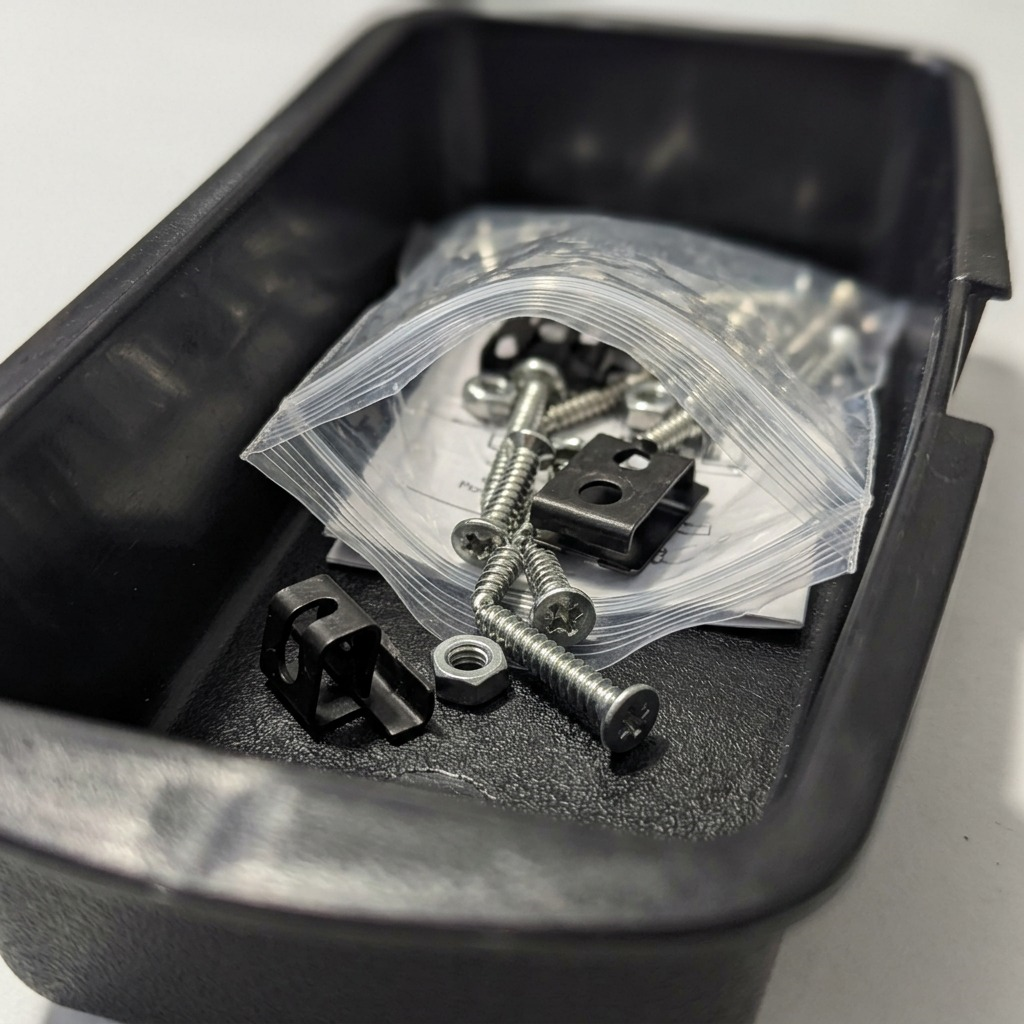 Macro detail of Rakabot Titan hardware kit, including screws and black hooks inside a container.